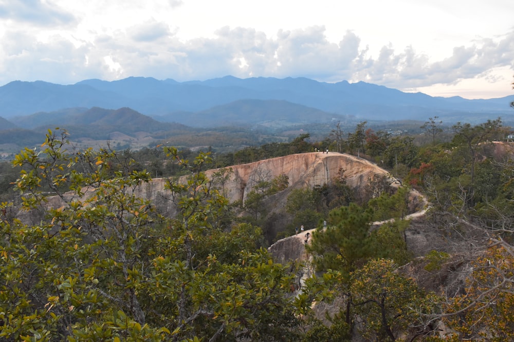 a scenic view of a mountain range with trees and mountains in the background