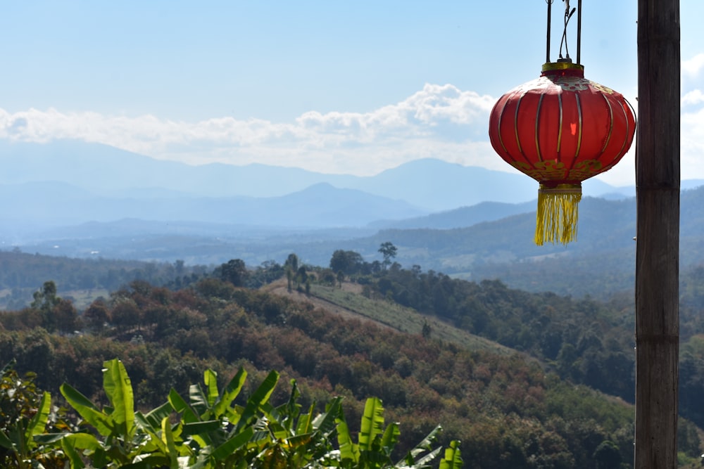 a red lantern hanging from a wooden pole