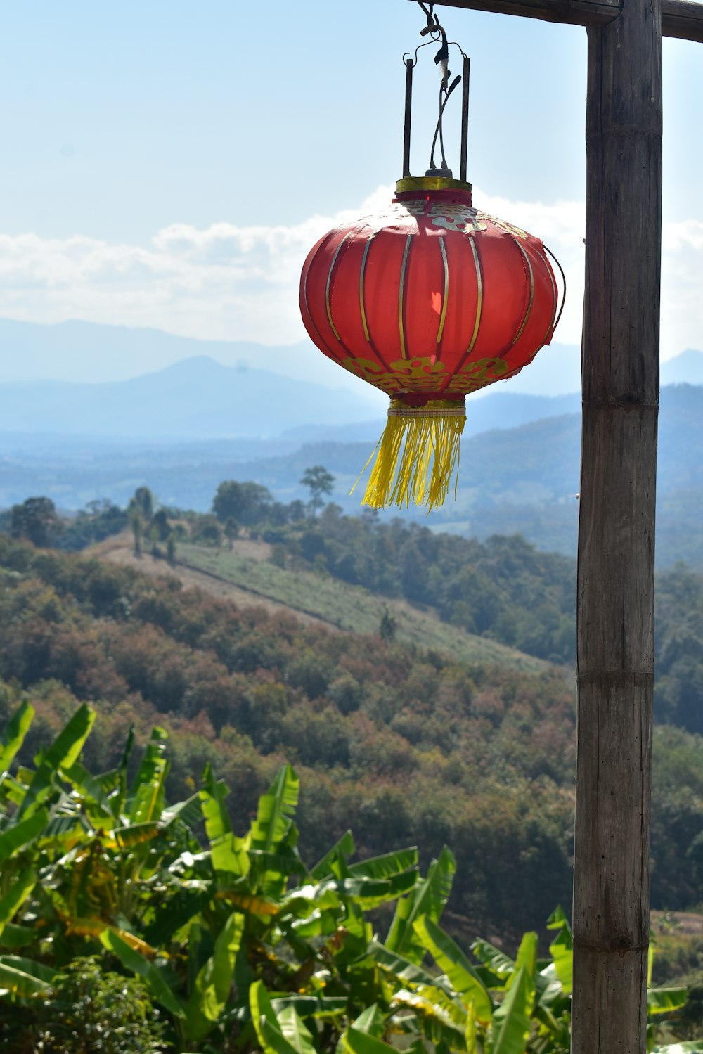 a red lantern hanging from a wooden pole