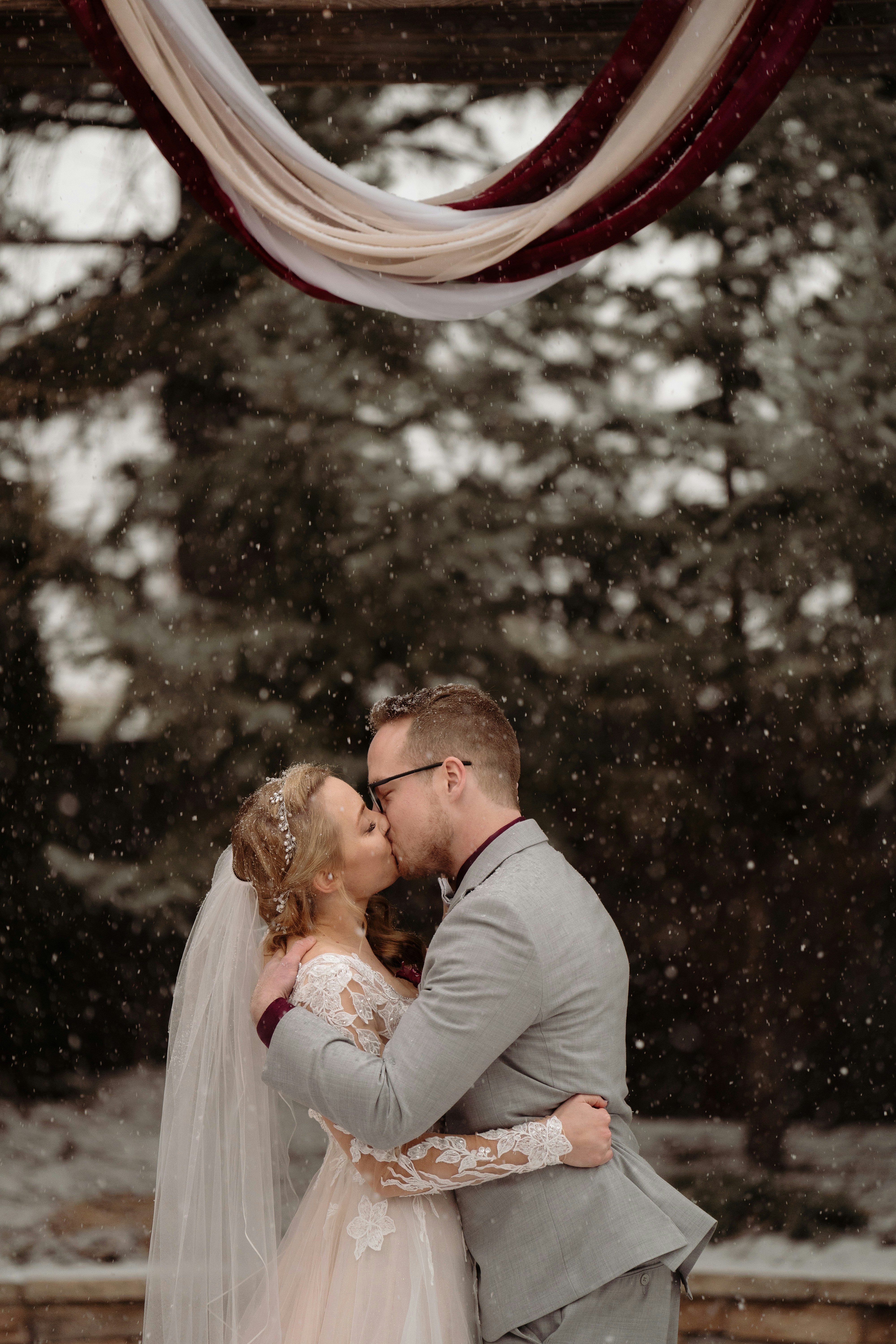 Una novia y un novio besándose en la nieve