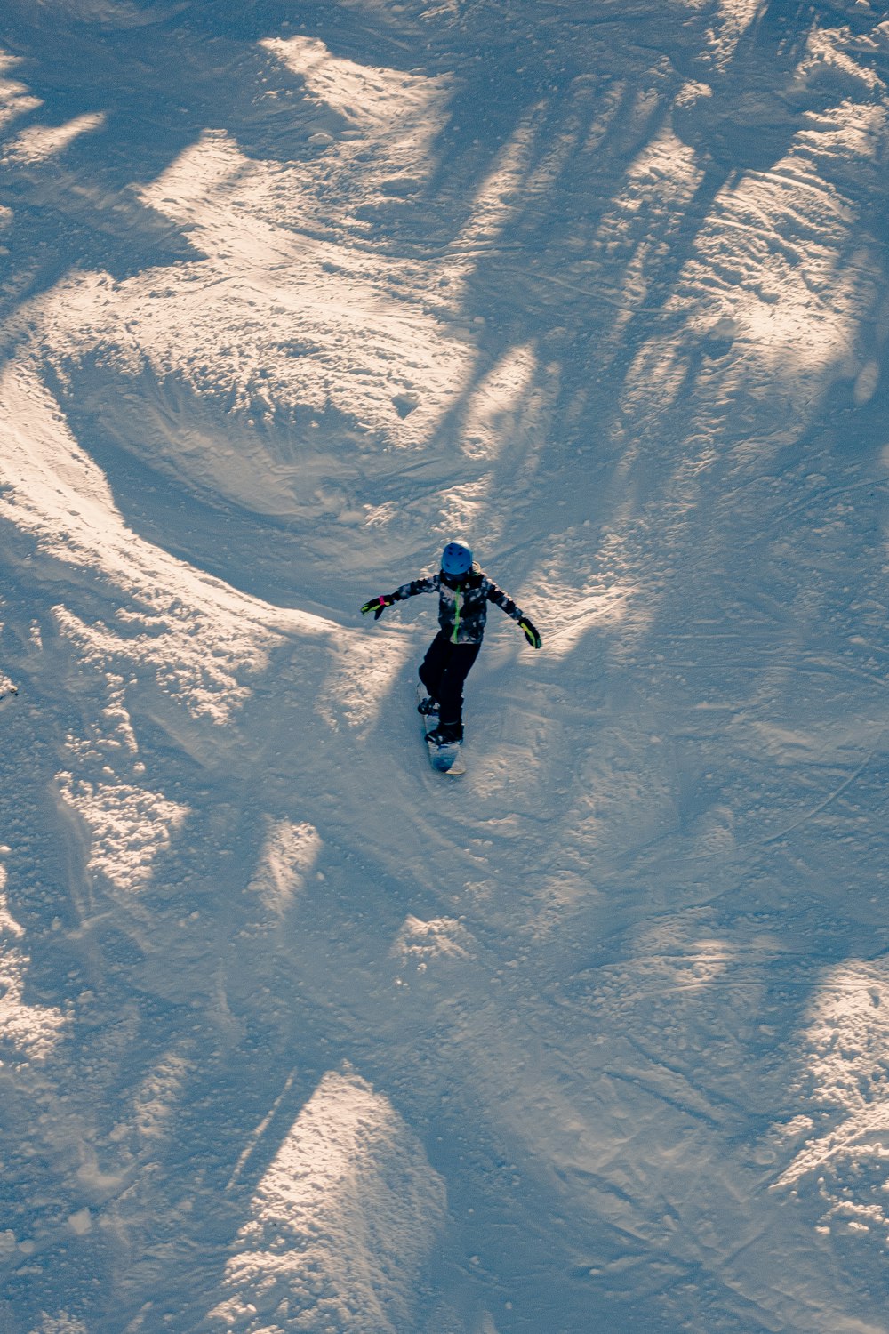 a person riding a snowboard down a snow covered slope