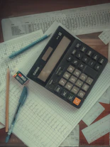a calculator sitting on top of a pile of papers