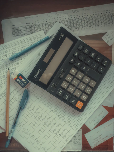 a calculator sitting on top of a pile of tax papers