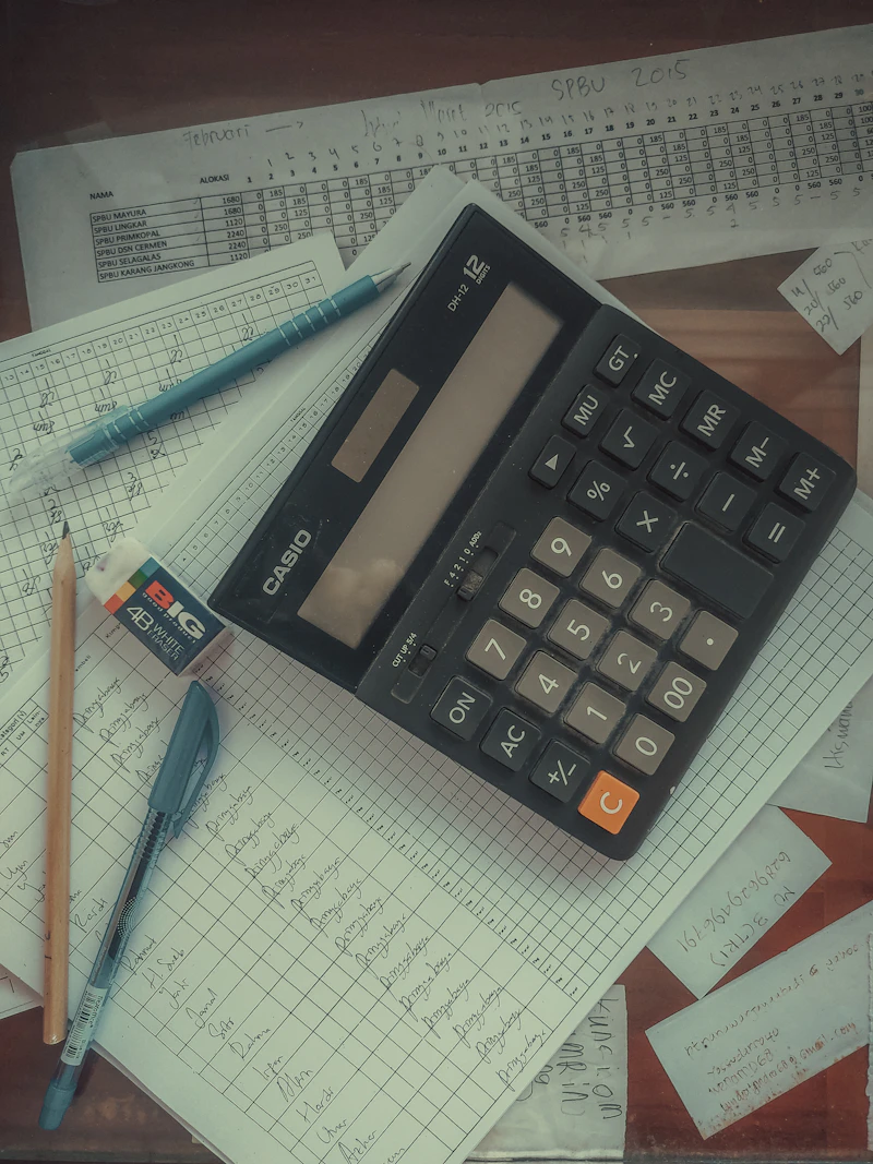 A calculator resting on a stack of paper documents.