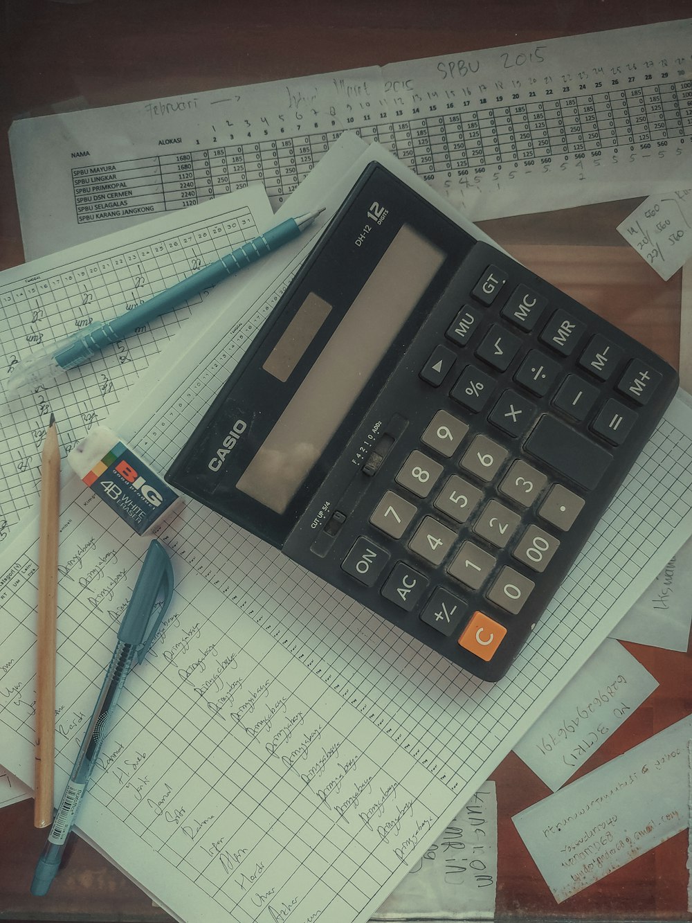 a calculator sitting on top of a pile of papers