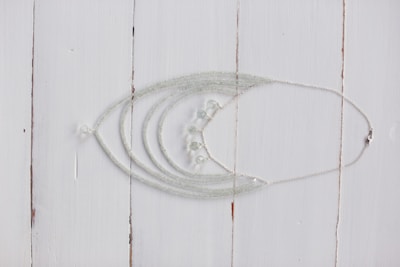 Delicate necklaces with pendants displayed on a wooden table