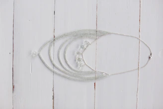 A collection of delicate beads and pearls arranged on a rustic wooden table.
