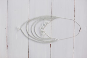 A close-up of a delicate handmade necklace featuring intricate designs.