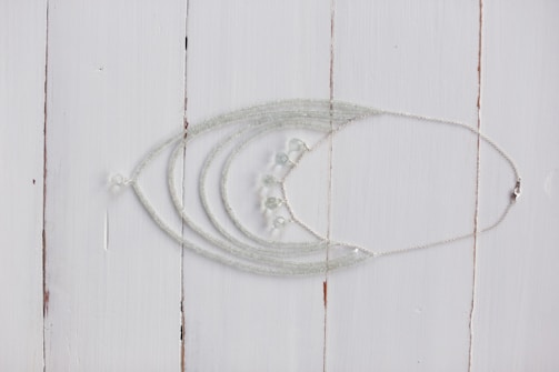 A collection of delicate silver necklaces on display.