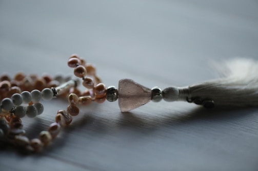 A close-up of a handcrafted gemstone necklace on a wooden surface.