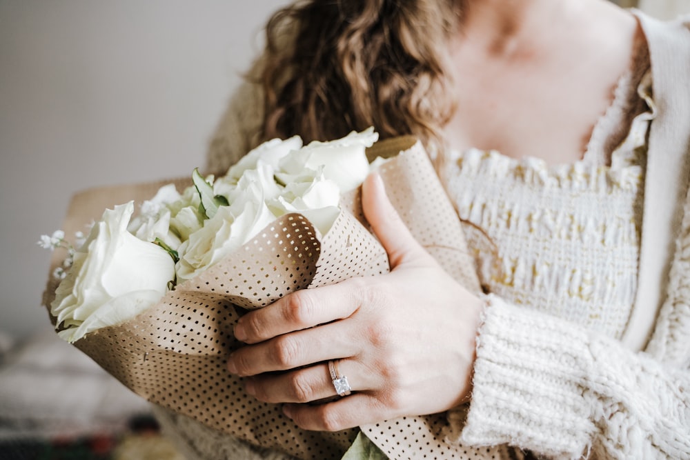 a close up of a person holding a bouquet of flowers