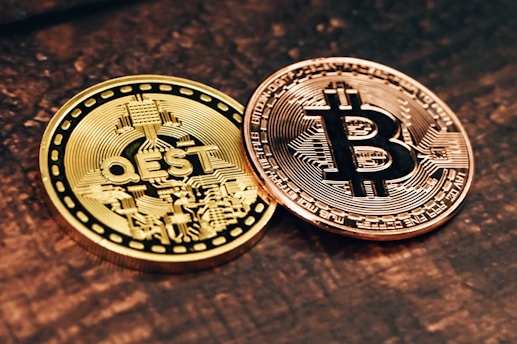 two gold and silver bitcoins sitting on a table
