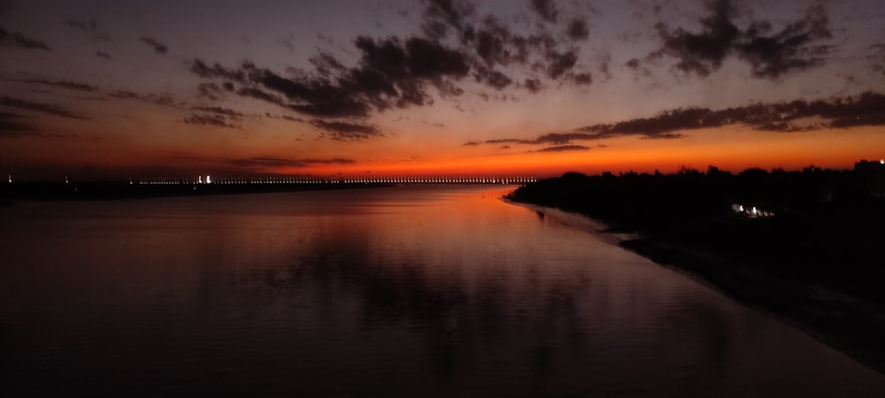 the sun is setting over a body of water