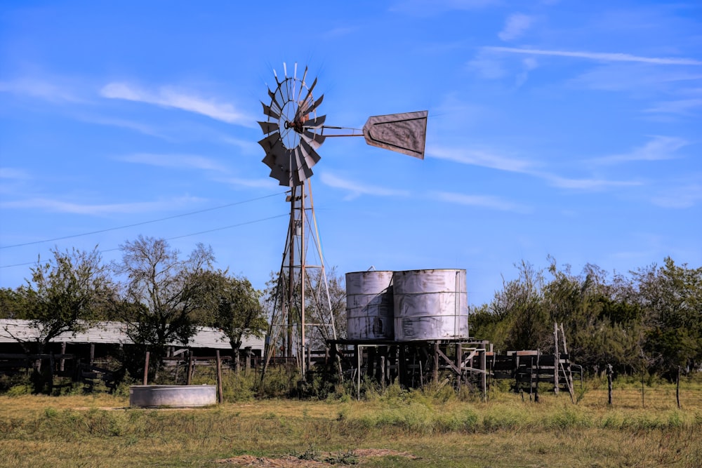an old farm with a windmill and water tanks
