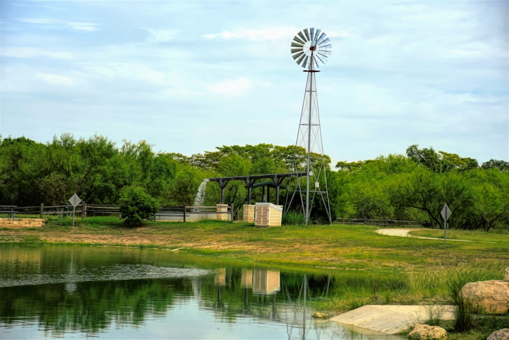 a windmill sitting on top of a lush green field