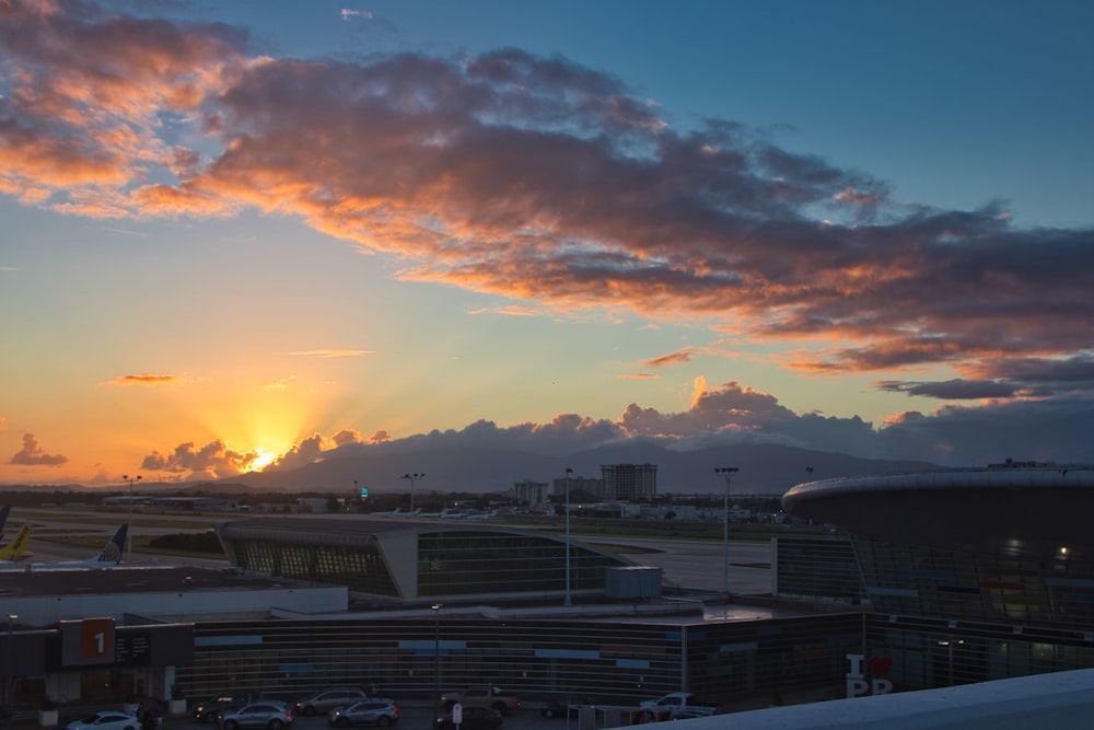 the sun is setting over an airport terminal