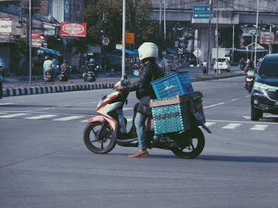 a person on a motor bike with boxes on the back