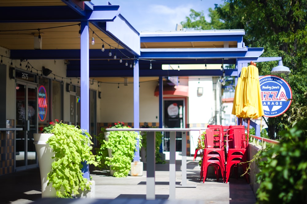 a row of red chairs sitting outside of a restaurant