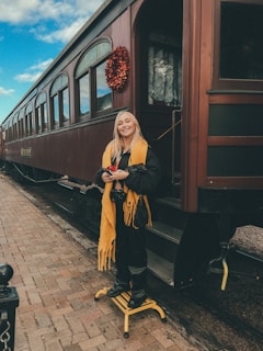 a woman standing on a platform next to a train
