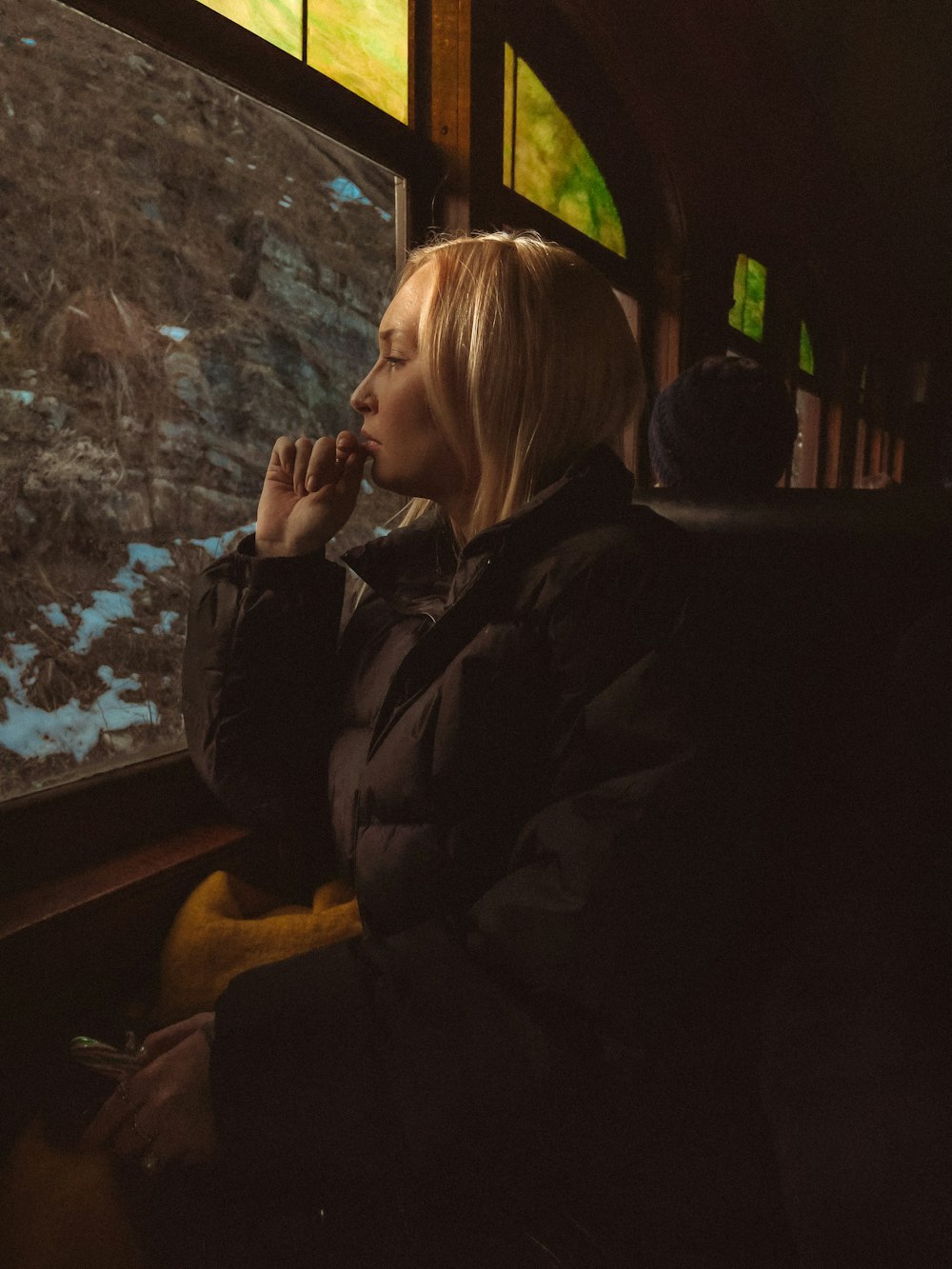 a woman sitting on a train looking out the window