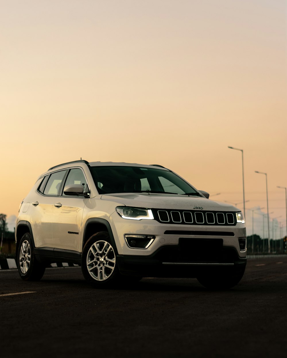 a white jeep parked on the side of a road