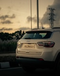a white jeep compass parked on the side of the road