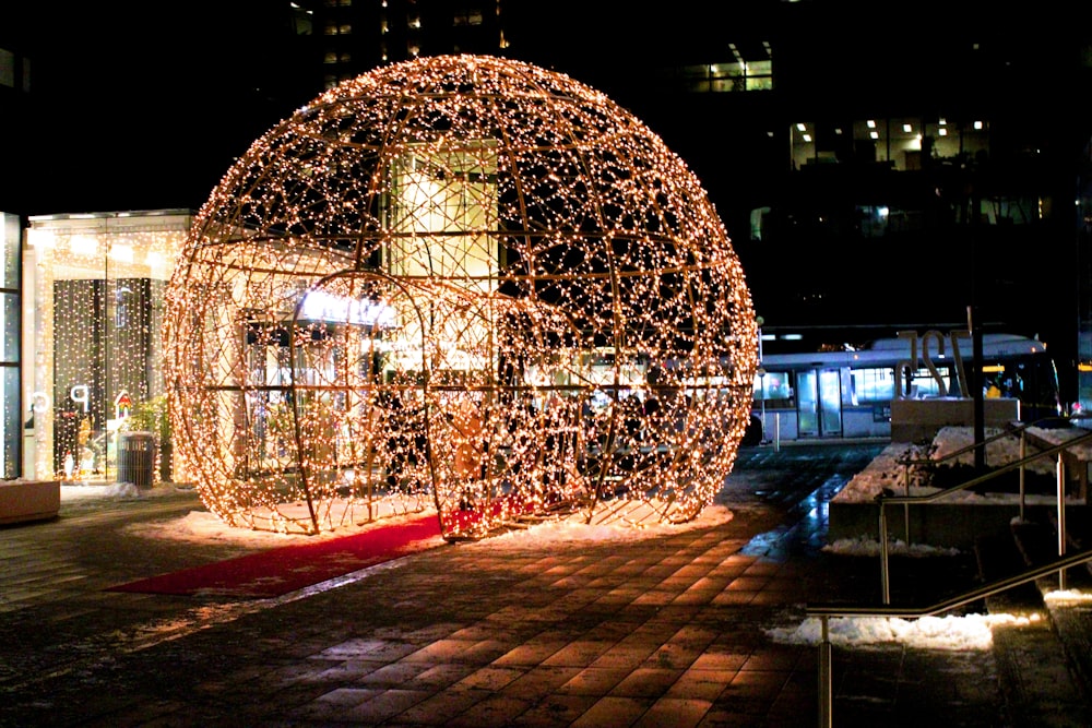 a large lighted ball on a brick walkway