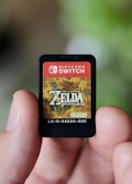 a hand holding a nintendo wii game card