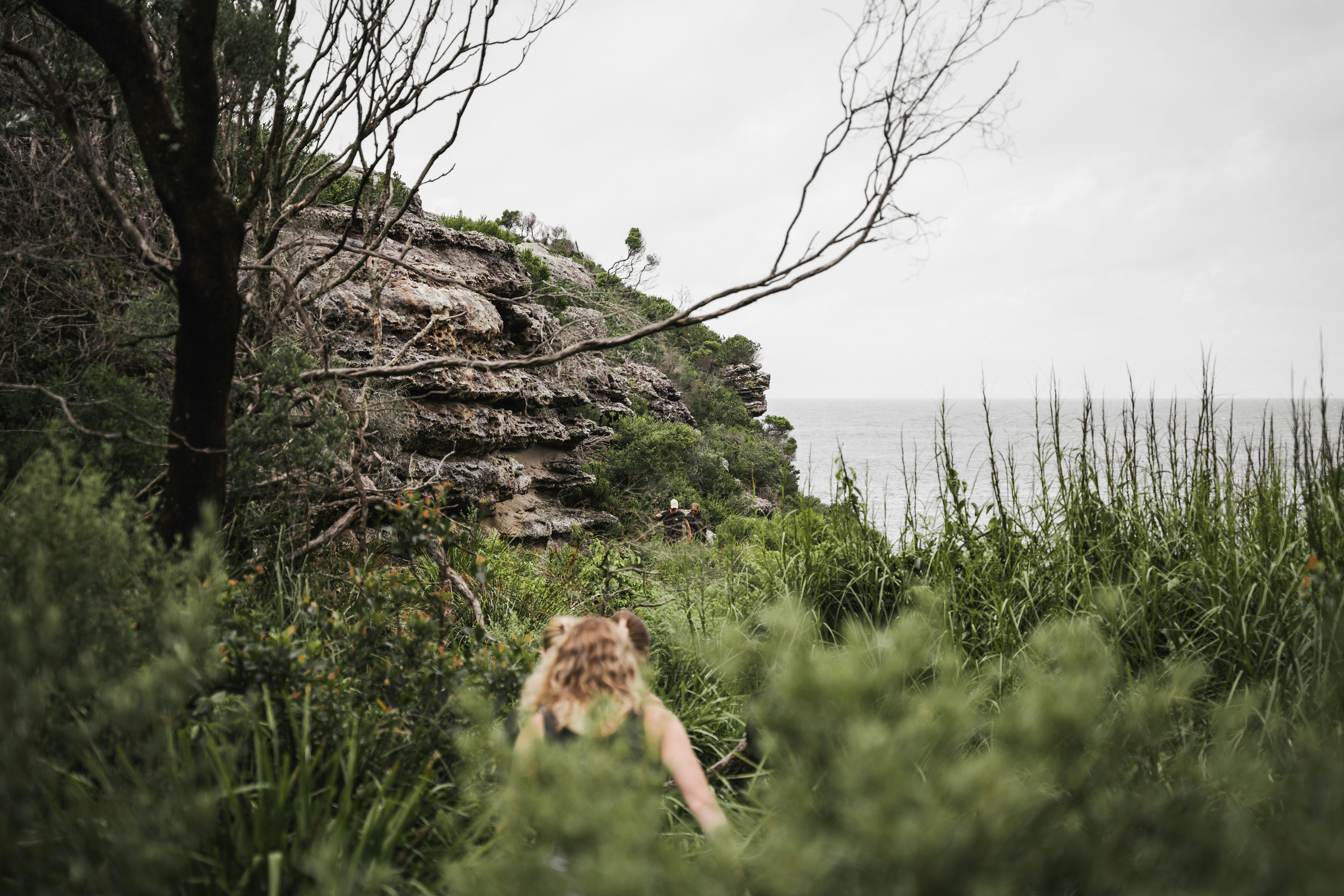 Une femme marchant dans une forêt verdoyante au bord de l’océan