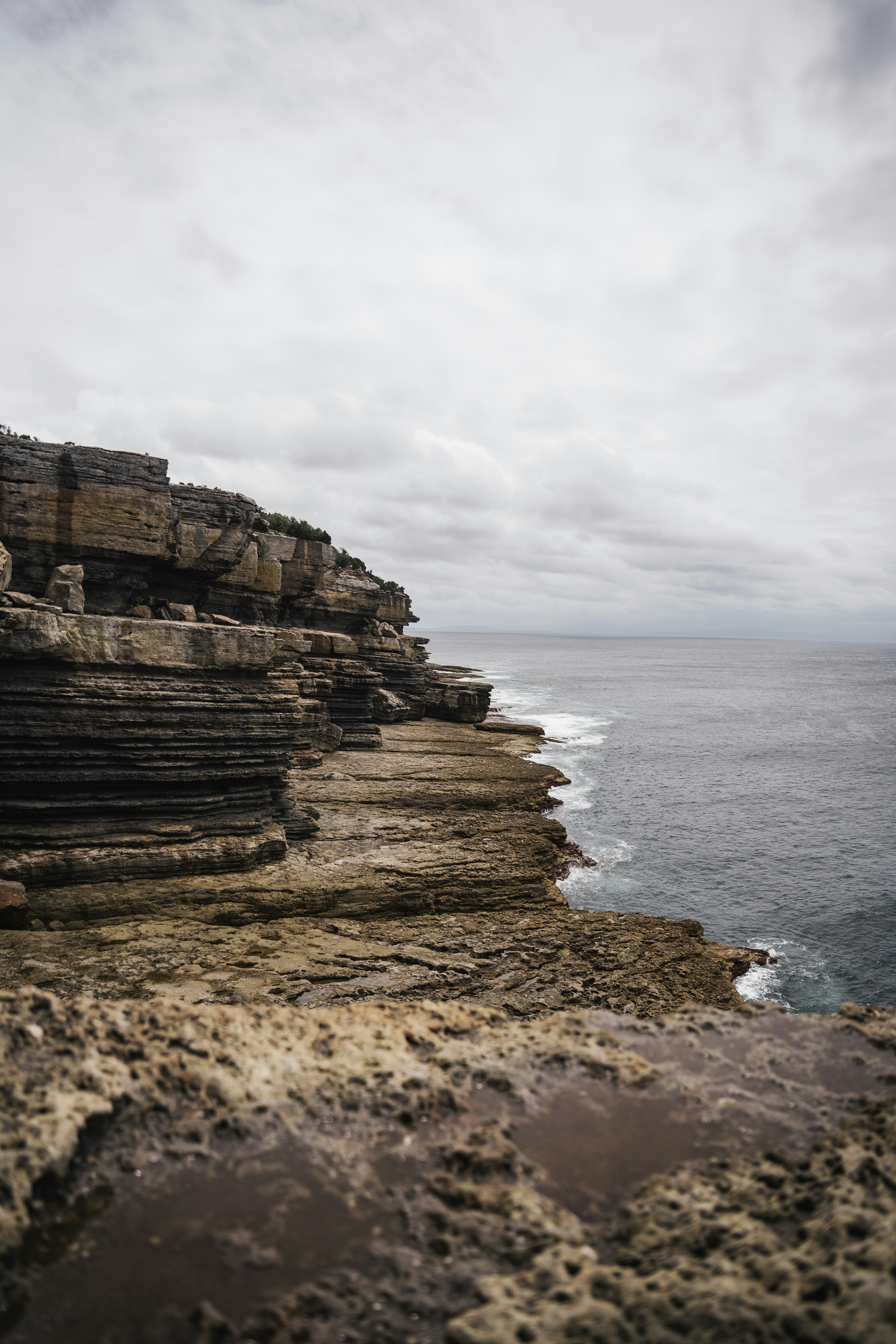 Une falaise rocheuse surplombe l’océan par temps nuageux