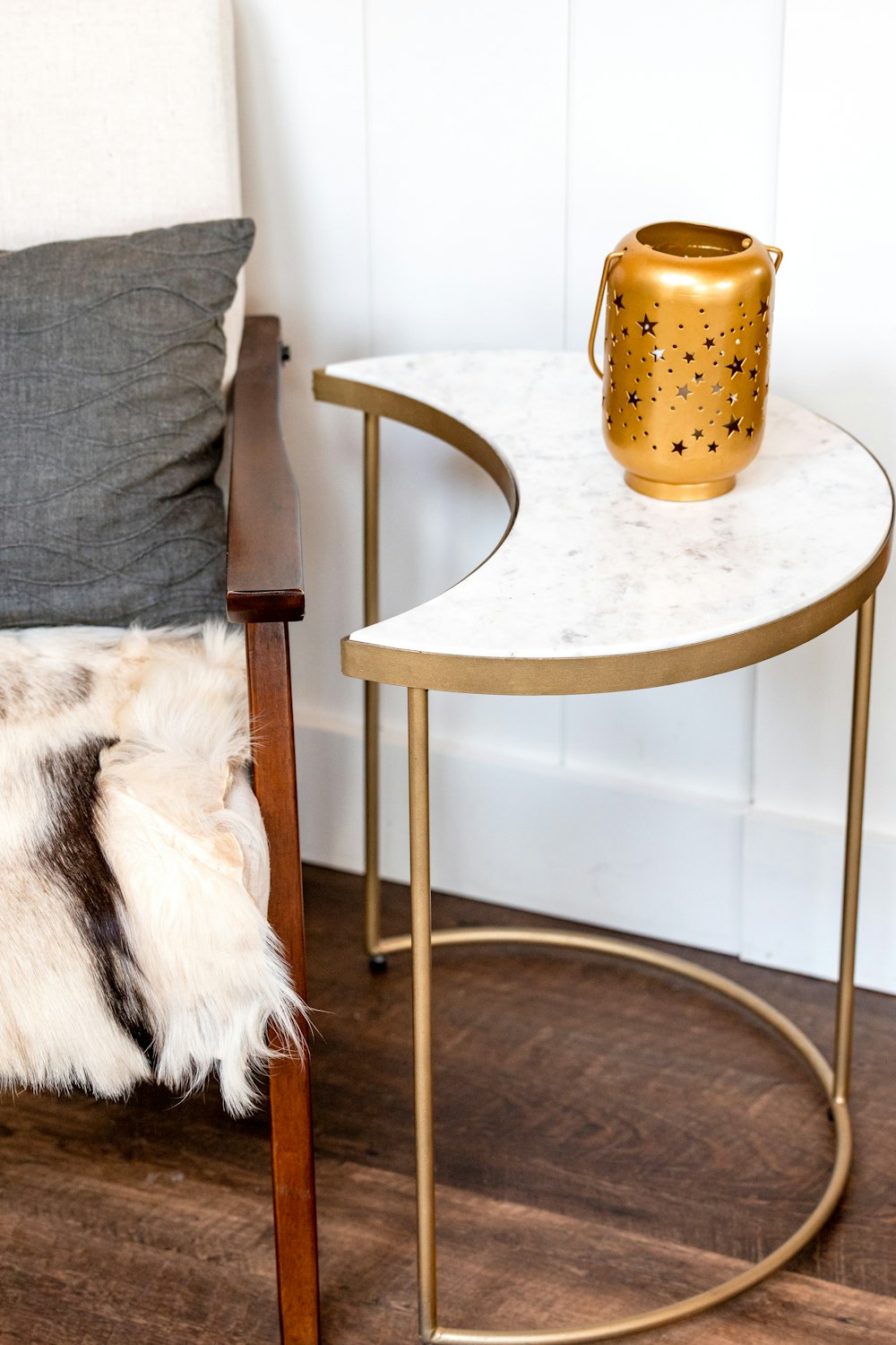 a table with a vase on it next to a chair