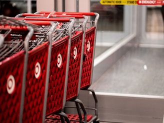 a row of red shopping carts sitting in front of a store