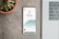 A smartphone displaying stock information is placed on a textured surface beside a laptop keyboard. The phone shows a graph with a price and percentage change for a stock, specifically Apple Inc. Next to the phone, there is a potted plant with green succulent leaves.