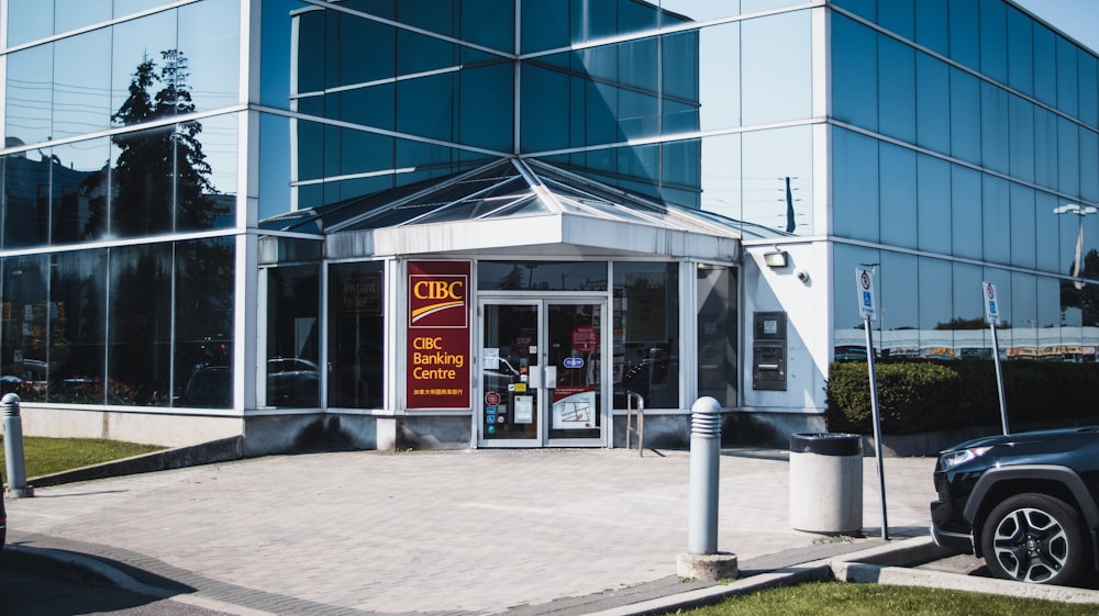 a car is parked in front of a glass building