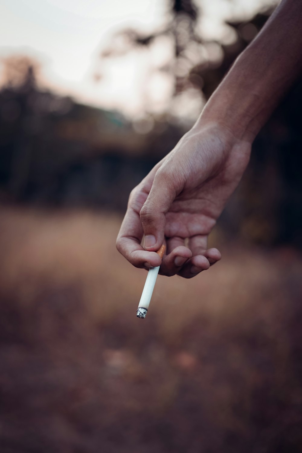 a person holding a cigarette in their hand