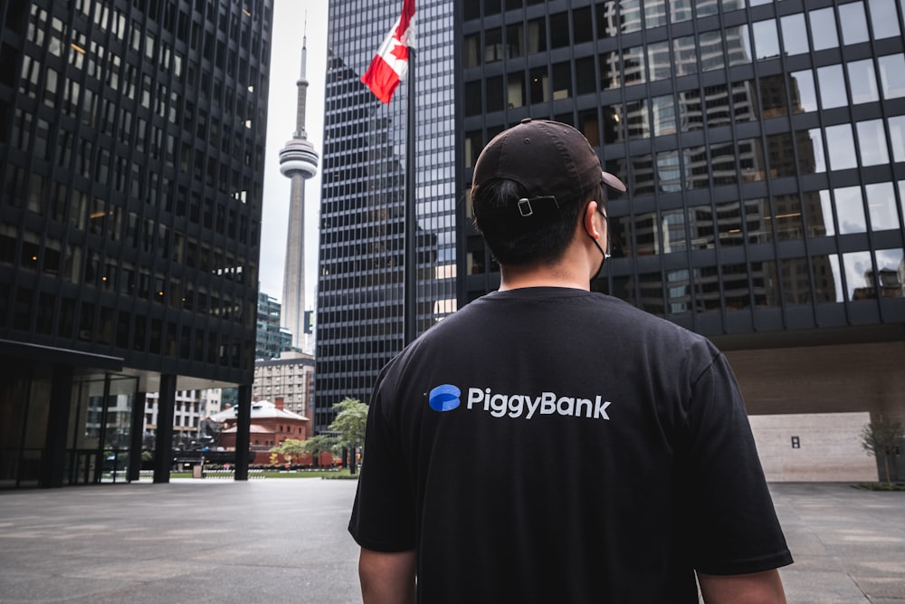 Un hombre en una alcancía T - camisa mirando una bandera canadiense