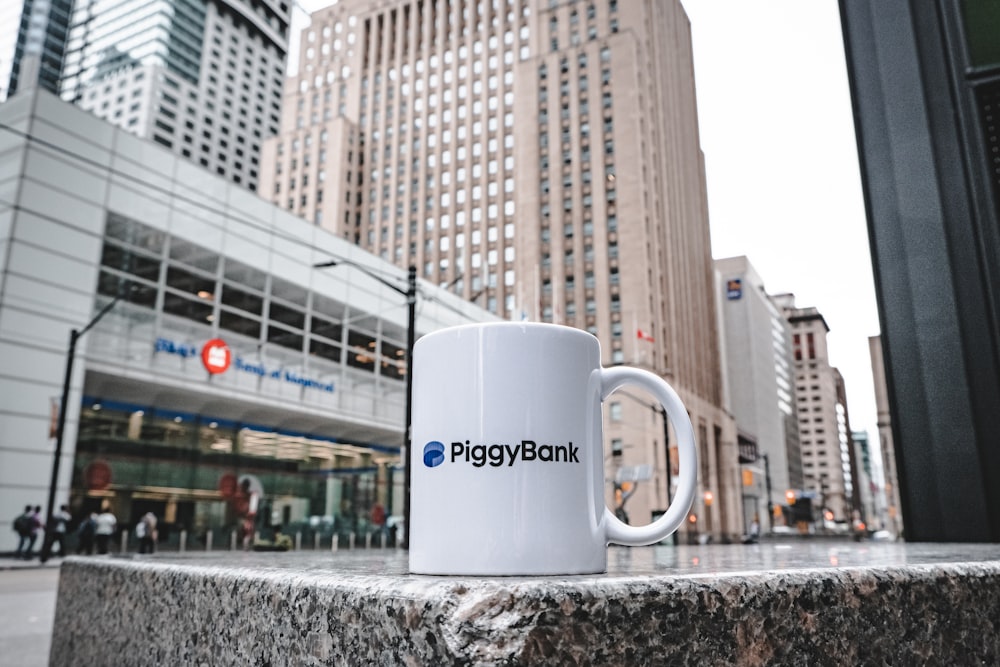 a white coffee mug sitting on top of a stone wall