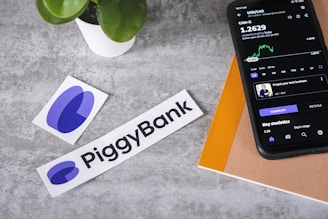 a cell phone sitting next to a piggy bank sticker
