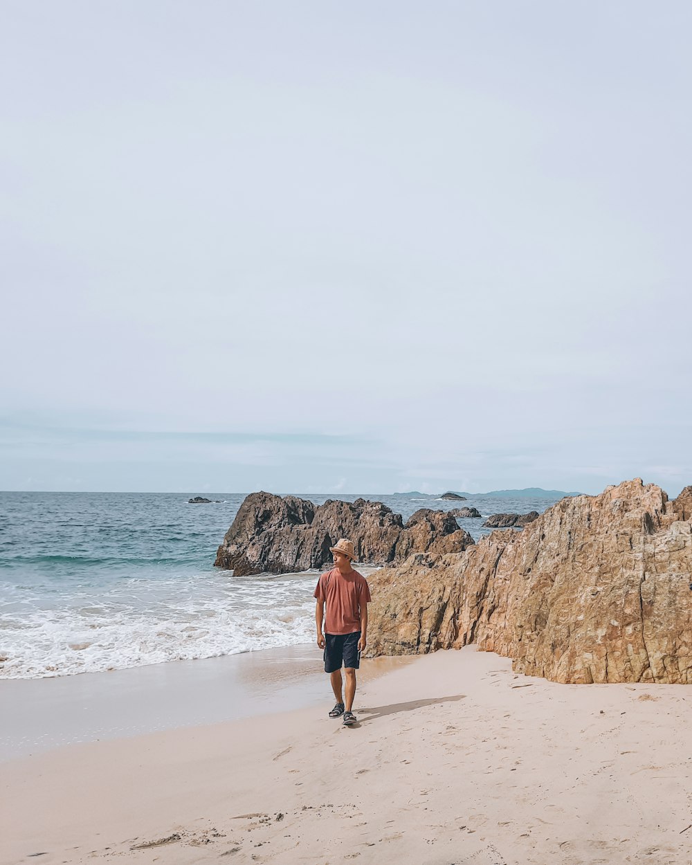 a man walking on a beach next to the ocean