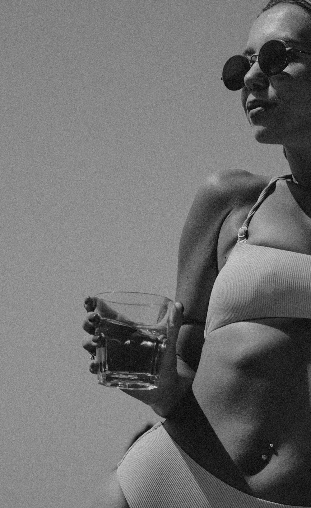 a woman in a bikini holding a glass of wine