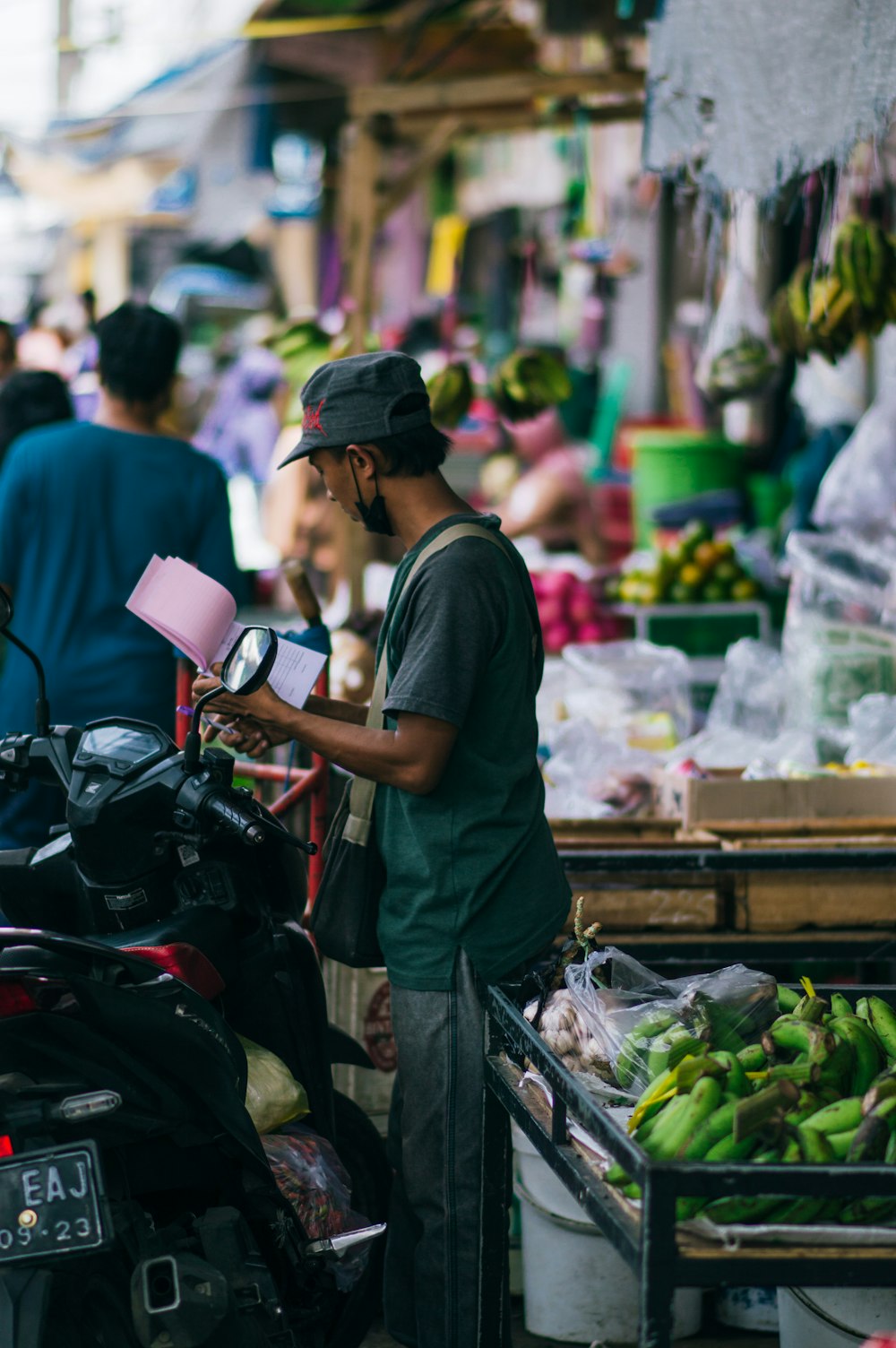 a man standing in front of a fruit and vegetable stand