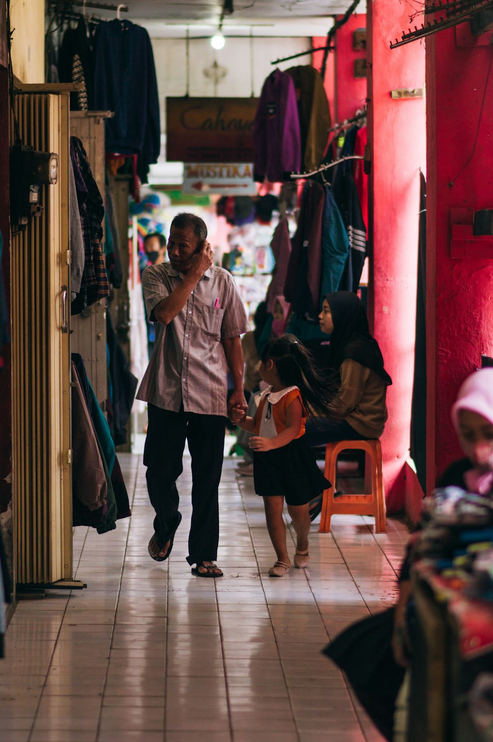 a man walking down a hallway next to a woman