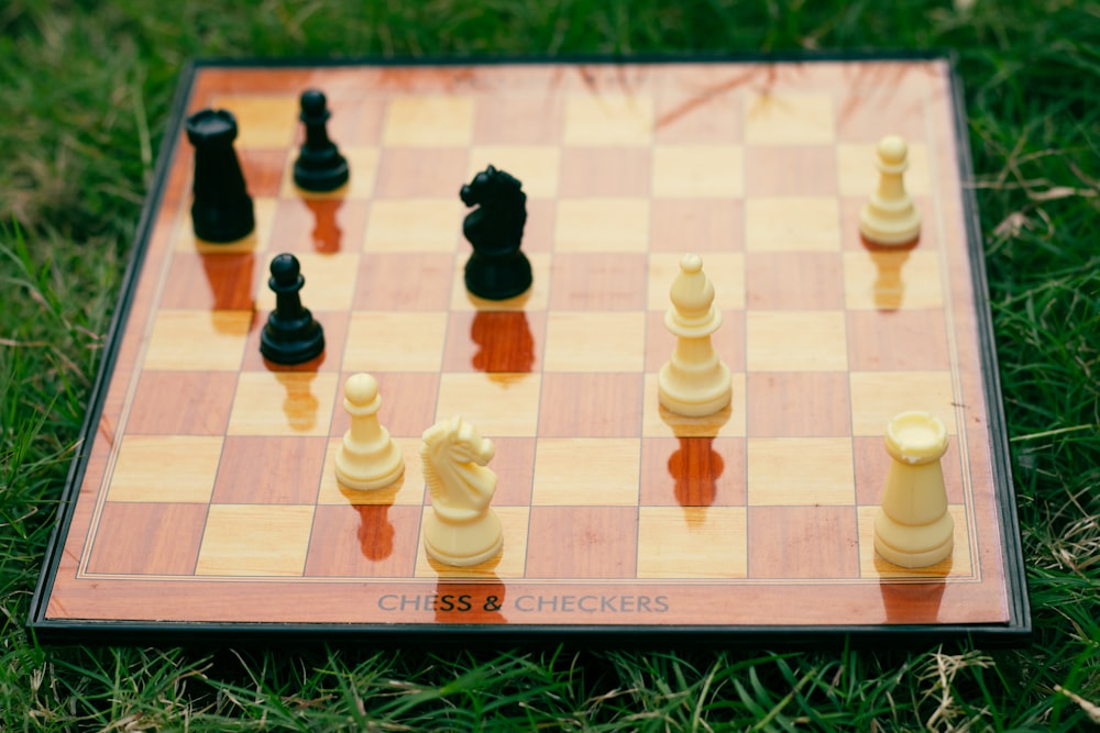 a close up of a chess board on the grass