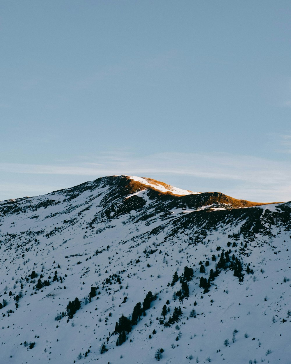 a mountain covered in snow under a blue sky