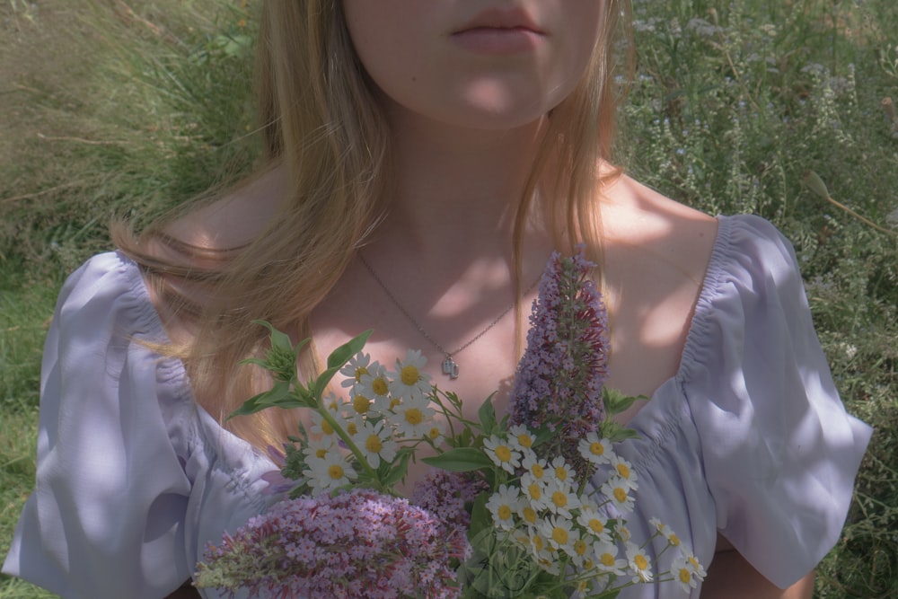 a woman in a white dress holding a bouquet of flowers