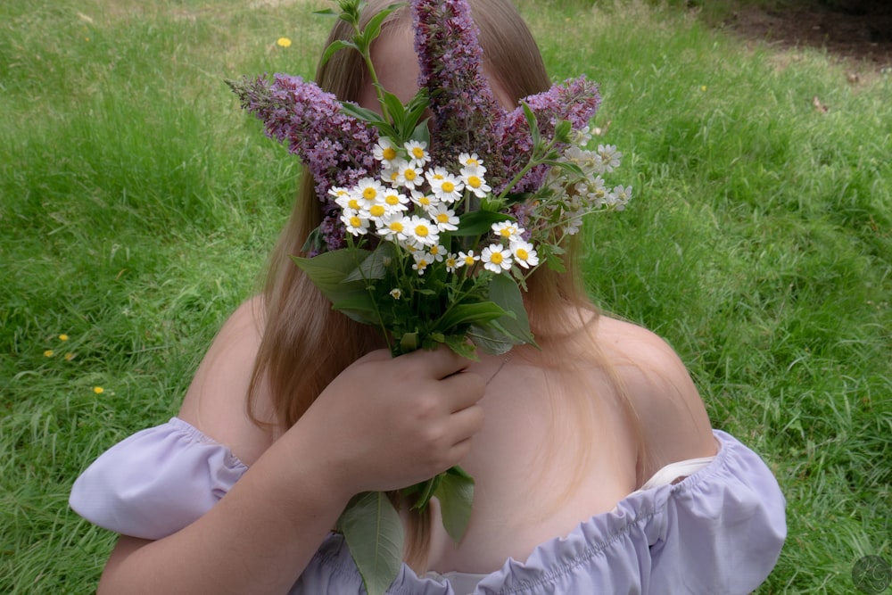 a woman in a dress holding a bunch of flowers