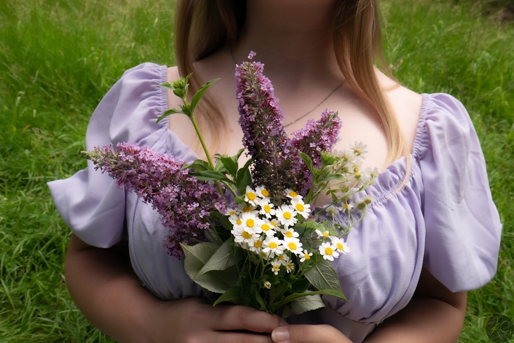 uma mulher em um vestido segurando um buquê de flores