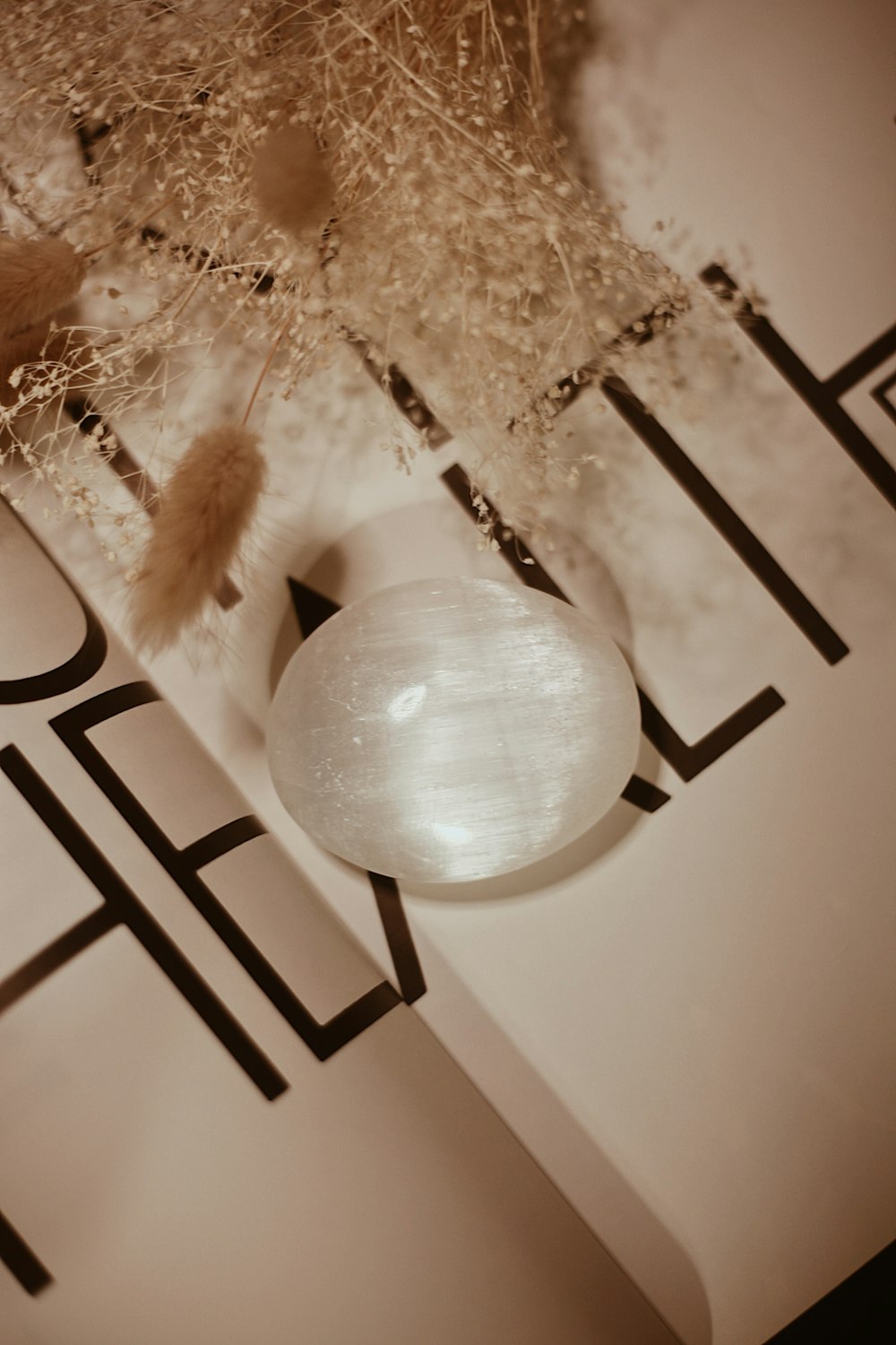 a white vase sitting on top of a book