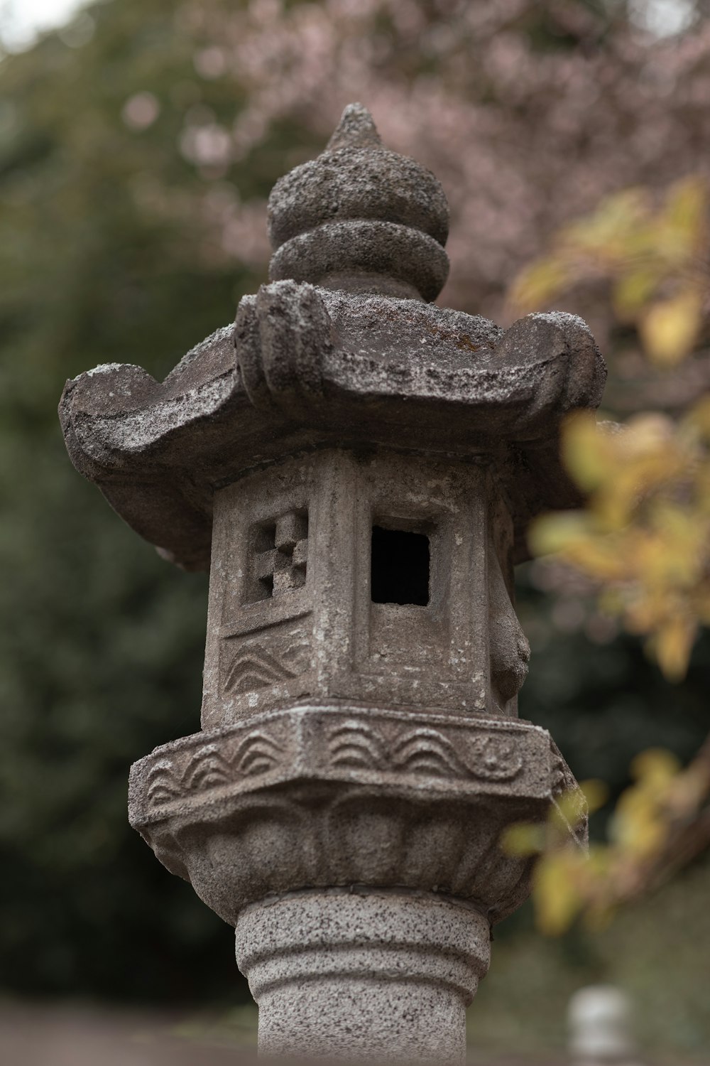 a stone lantern sitting in front of a tree