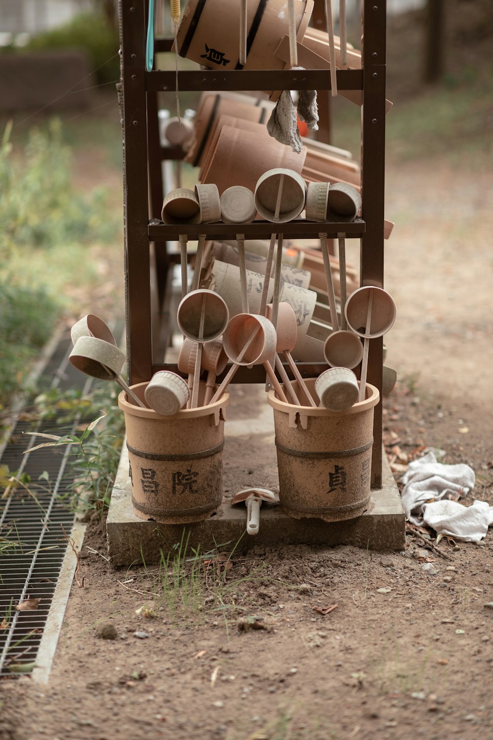 pots and pans are stacked on a rack outside